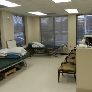 A clean and well-lit hospital room featuring patient beds and a waiting area.