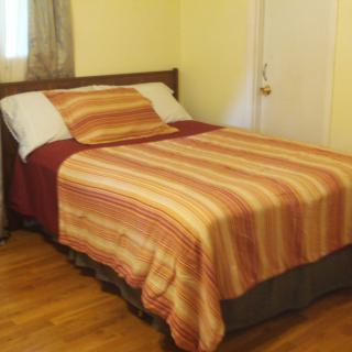 A neatly made bed with striped bedding in a cozy bedroom.
