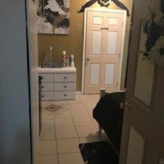 View into a bathroom featuring a sink, cabinet, and bathtub.