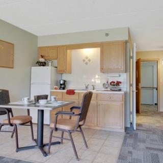 A small apartment kitchen and dining area with a table, chairs, and refrigerator.