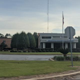 A view of a modern building surrounded by well-maintained landscaping and trees.