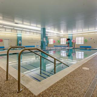 A spacious indoor swimming pool with a clean and inviting atmosphere, perfect for relaxation and exercise.