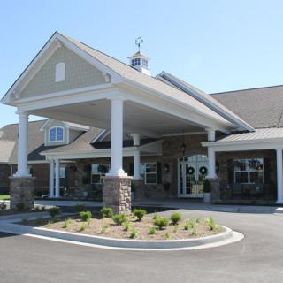 A front view of a commercial building with a covered entrance and landscaped surroundings.