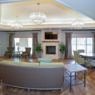 A modern living room with elegant chandeliers, a cozy fireplace, and stylish furnishings.