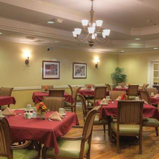 A cozy dining room with elegantly set tables and a warm ambiance.