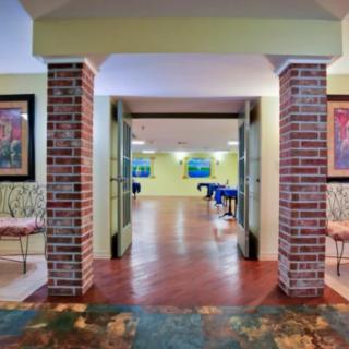 A modern interior hallway featuring brick pillars and colorful artwork.