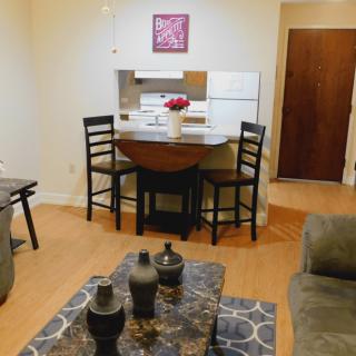 A cozy living and dining area with a small table, chairs, and a couch adjacent to the kitchen.
