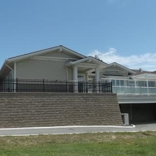 A modern house with a spacious front yard and clear blue skies.