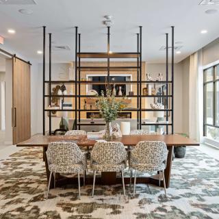 A modern dining area with stylish open shelving and contemporary furnishings.
