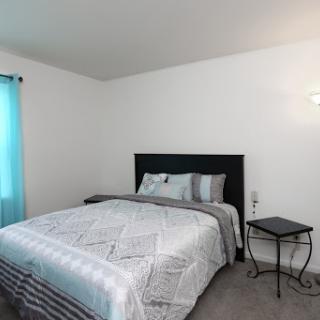 A cozy and modern bedroom featuring a neatly made bed and stylish decor.