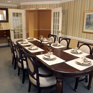 A neatly set dining table with elegant chairs in a well-decorated room.