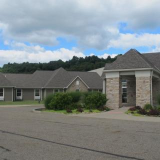 A residential building under a cloudy sky with a driveway in the foreground.