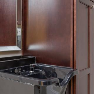 A modern kitchen interior featuring a black stove and wooden cabinets.