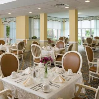 An elegantly set dining room with neatly arranged tables and chairs.