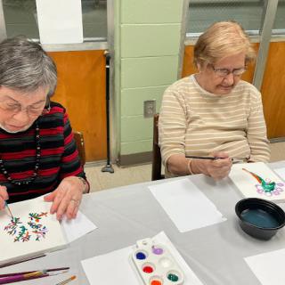 Two seniors enjoying a watercolor painting session.