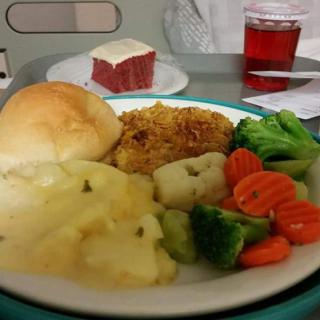 A hospital meal with mashed potatoes, vegetables, fried chicken, and a bread roll.