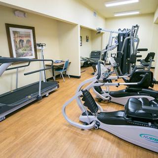 A small gym with various fitness equipment and exercise machines.