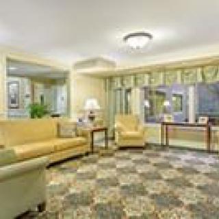 A cozy living room with comfortable seating, stylish lighting, and a patterned carpet.