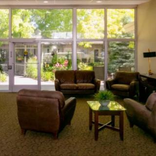 A cozy lobby area with comfortable seating and large windows overlooking greenery.