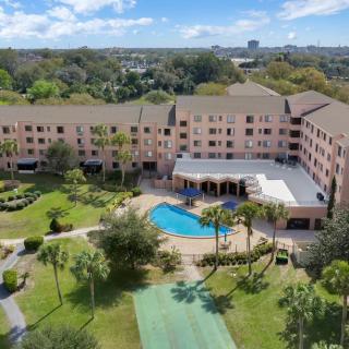 Aerial view of a hotel with a swimming pool and surrounding gardens.