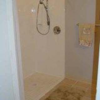 A bathroom with a walk-in shower and a towel hanging on the rack.