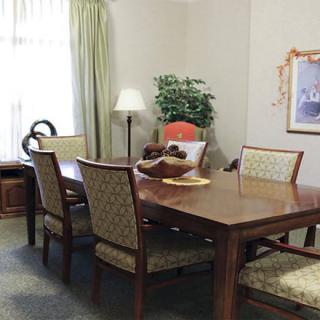 A dining room with a wooden table and chairs, adorned with decorative items and a plant.