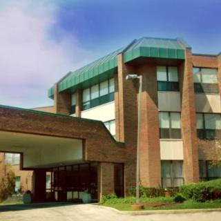 A modern hospital building with a brick facade and large windows.