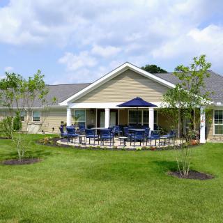 A modern house with a spacious backyard featuring a patio and outdoor seating area.