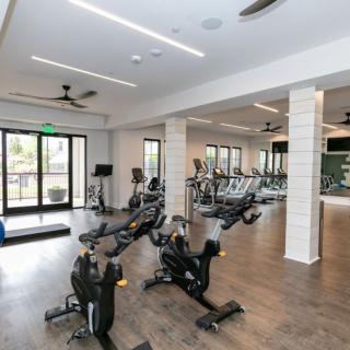 A modern gym with various exercise equipment and stationary bikes.