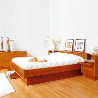 A minimalist bedroom with wooden furniture and modern decor.