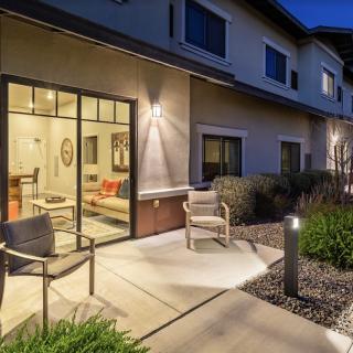 A modern residential patio with outdoor seating, illuminated at night.