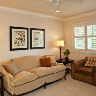 A cozy living room with a sofa, armchair, and warm lighting.