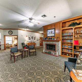 A cozy living room featuring a fireplace, bookshelves, and comfortable seating.