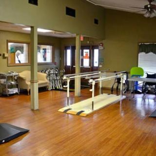 A physical therapy room equipped with parallel bars and exercise equipment.