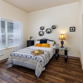 A modern bedroom with stylish decor, including a bed, bedside tables, and wall art.