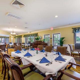 An elegantly set dining room with neatly arranged tables and chairs.
