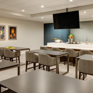 A modern dining area with tables, chairs, and artwork on the walls.