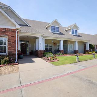A suburban residential house with a well-maintained front yard and brick facade.