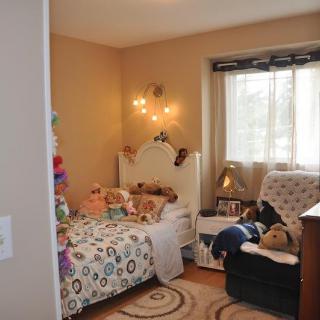 A cozy child's bedroom decorated with teddy bears and soft lighting.