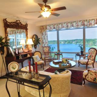 A cozy living room with vintage decor and a stunning lake view through large windows.