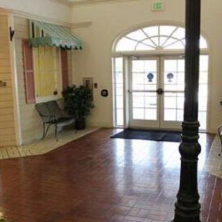 A welcoming lobby area with wooden floors, a bench, and decorative elements by the entrance.