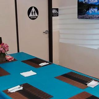 A dining setup in a restaurant with a blue tablecloth and neatly arranged placemats.