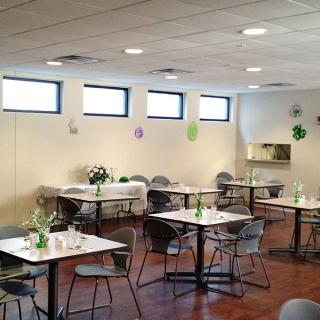 A decorated dining area with tables and chairs set up for an event.