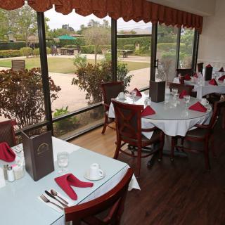A cozy restaurant dining area with neatly arranged tables and a scenic window view.
