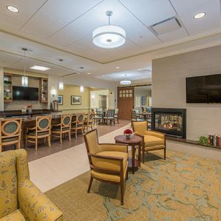 A modernly designed lounge area with comfortable seating, a fireplace, and a television.
