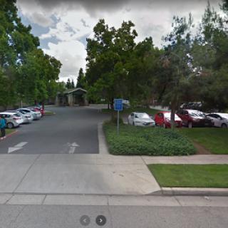 A view of a parking lot surrounded by trees and greenery.