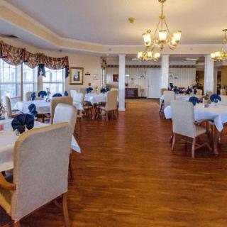 Elegant dining room with neatly arranged tables and chandeliers.