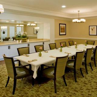 A well-arranged dining or conference room with a long table and elegant chairs.