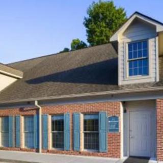 A brick building with blue shutters and large windows.