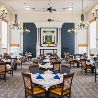 An elegant dining room with neatly arranged tables and chandeliers creating a sophisticated atmosphere.